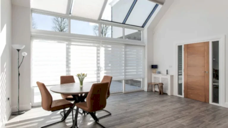 Beautiful modern dining room showing benefits of self build home with motorised aura day night blinds and cellular roof window blinds