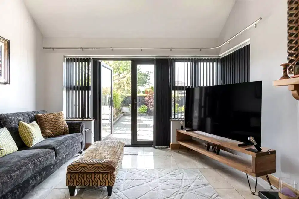 Modern living room with white PVC vertical blinds for patio doors, offering a sleek, contemporary style.