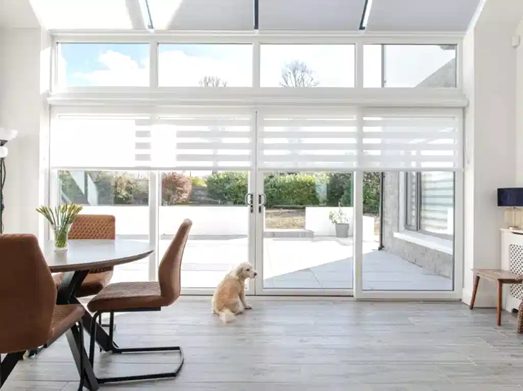 Discover the Benefits of Day and Night Blinds: Pro Tips 2024 Sunny Dining Room with Light Day and Night Blinds on large Sliding Glass Doors Northern Ireland Village Blinds and Shutters